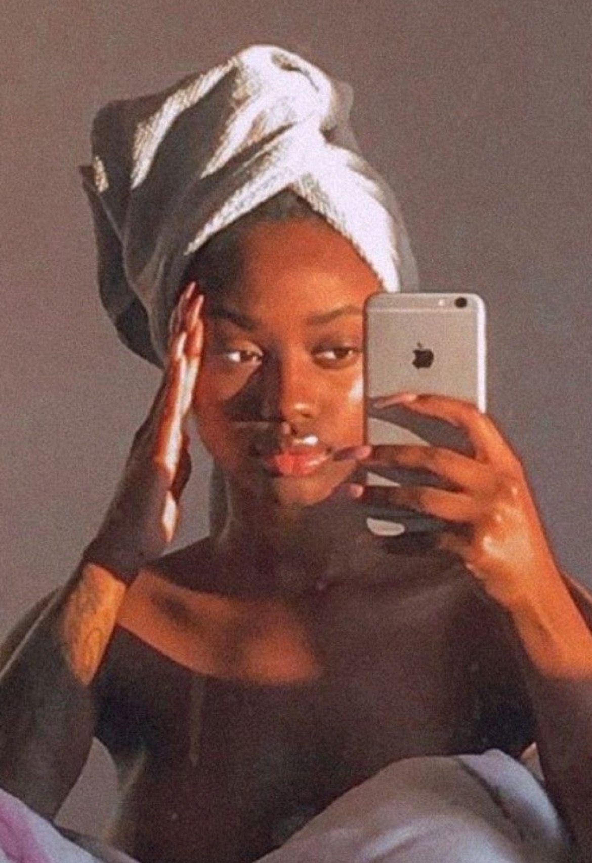 Black girl in bed golden hour slugging skincare routine 