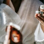 crop ethnic woman with jar of cream against mirror